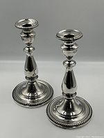 Pair of sterling silver candlestick holders front angle