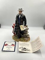 Figurine with certificate of authenticity and documentation displayed in front