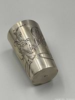 Cup angled to show hallmarks at rim and front floral etching