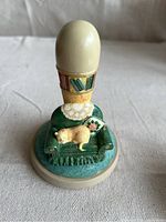 Front view of ceramic cookie stamp featuring a cat sleeping on a couch with bookshelf and decorative details.