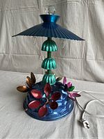 Full view of folk-art lamp showing blue base and lampshade, green Bundt section stem, and crystal top finial