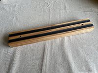 Wooden magnetic cutting tool holder showing black magnetic strips on the front side and mounting holes on the back side.