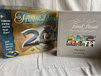 Two Trivial Pursuit boxes side by side: 20th Anniversary edition and 1980's Master Game edition.