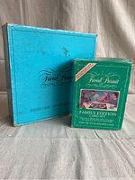 Two vintage Trivial Pursuit card sets side by side on a fabric surface, showing the original boxes with Trivial Pursuit branding and imagery