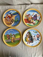 All seven McDonald's plastic plates laid out showing different seasonal illustrations and characters from 1977.
