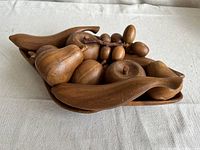 Top angle of the vintage wooden carved fruit arranged in wooden bowl, showing various fruit pieces including pears, grapes, bananas and apples with natural wood finish and slight wear.