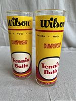 Front view showing Wilson branding and tennis balls graphics on the two glasses.