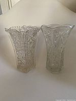 Front view of two clear vases showing detailed cut patterns