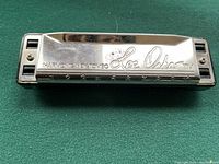 Front view of the harmonica showing engraved metal cover with 'Lee Oskar' and hole numbers 1-10