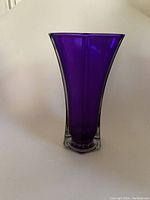 Front view of a purple glass vase with a clear base on a white background.