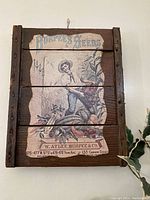 Front view of vintage Burpee's Seeds advertisement on wood with visible rustic texture and detailed farmer graphic.