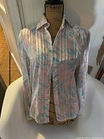 Front view of vintage Sarah Taylor ladies blouse with pastel striped pattern and classic collar on mannequin.