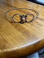 Close-up photo showing the vintage metal bracelet with an oval cameo in the center, depicting a woman's profile.