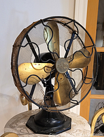 Front-left three-quarter view showing cage guard, blades and base