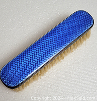 Top view of the antique brush showing blue guilloche enamel and sterling silver edges.