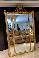 Full front view of the mirror showing three vertical panels and overall design.