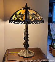 Overall view of lamp lit, showing shade pattern and base form.