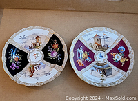 Overview of both Meissen plates showing contrasting panel colors and gilt borders