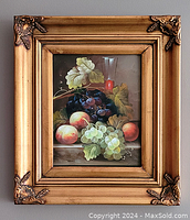 Front view of the oil on board painting featuring grapes, peaches, leaves, and a glass in the background with ornate gold frame.
