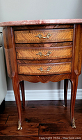Front view showing entire side table with marble top and three drawers