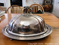 Side view of the full set with meat dome covering the platter on wooden table.