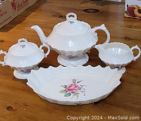 Overall view of four-piece tea set arranged on table
