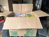 Photo of a cardboard box fully open showing multiple CDs inside.