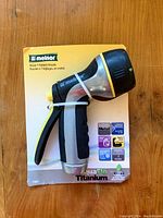 Photo of new Melnor AquaFlo Titanium metal hose nozzle in original packaging, showing the item clearly.