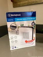 Front view of the Westinghouse digital ceramic oscillating heater box showing key features like digital display, oscillation, and eco mode.