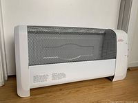 Front and side view of white Sunbeam radiating heater with metal mesh front and controls on side