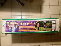 Photo of the unopened boxed toddler swing showing product branding and usage illustration.