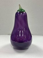 Full view of glass eggplant figurine showing purple body and green stem