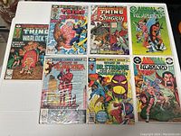 Top down photo showing 8 comics from Marvel Comics Group and DC Comics. Titles include The Thing, Stingray, Warlock, Elektra, Dr. Strange, Yellow Jacket, and Annual Warlord.