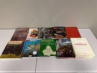 Ten hardcover art books arranged on a white surface showing covers and spines, various art-related topics.