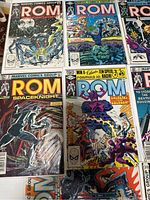Photo showing nine ROM comic books with various cover art including space theme, robotic warriors, and battles, all under Marvel Comics Group.