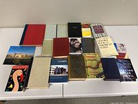 Overview of 19 assorted books arranged on a white table; includes travel guides, fiction, poetry, and genre fiction guides.