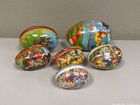 Lot of six vintage German paper mache Easter eggs decorated with colorful Easter themes, arranged in a group.