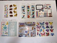 Shows multiple sheets of stickers laid out in two rows with various themes such as animals, skiing, Victorian children, art supplies, travel, butterflies, and flowers.