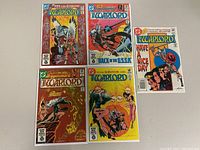 Five Warlord comic books displayed in a group on a flat surface, showing front covers.