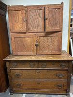 Front view of entire oak Hoosier cabinet showing upper and lower cabinet sections with doors and drawers.