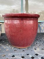 Exterior view of the red glazed garden pot showing the round shape and glaze surface