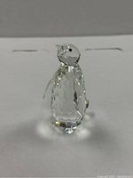 Front view of the clear faceted crystal penguin figurine with black eyes.