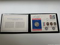 Original presentation portfolio with coin, stamps, and informational card about the Bicentennial of the French Revolution.