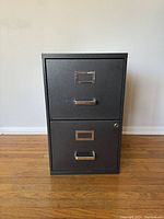 Front view of grey metal filing cabinet showing two drawers with handles and label holders.