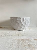 Front view of large white ceramic planter pot, showing honeycomb texture and shape.
