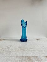 Photo of a blue swung glass vase showing its height and five finger-like rim design.