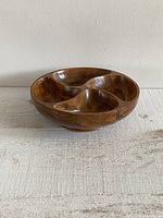 Front view of vintage wooden four-section snack bowl showing divided compartments and wood grain.
