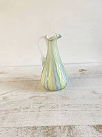 Front and side view of pastel rainbow satin glass jug with quilted vertical ridges and handle.