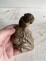 Front and partial side view of the stoneware field mouse on a corn cob sculpture held in hand, showing detailed mouse face and corn kernel textures.