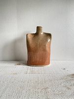 Front view of the bust-shaped vase showing the flat shoulders and thin neck, highlighting the earth tone glaze with a speckled finish.